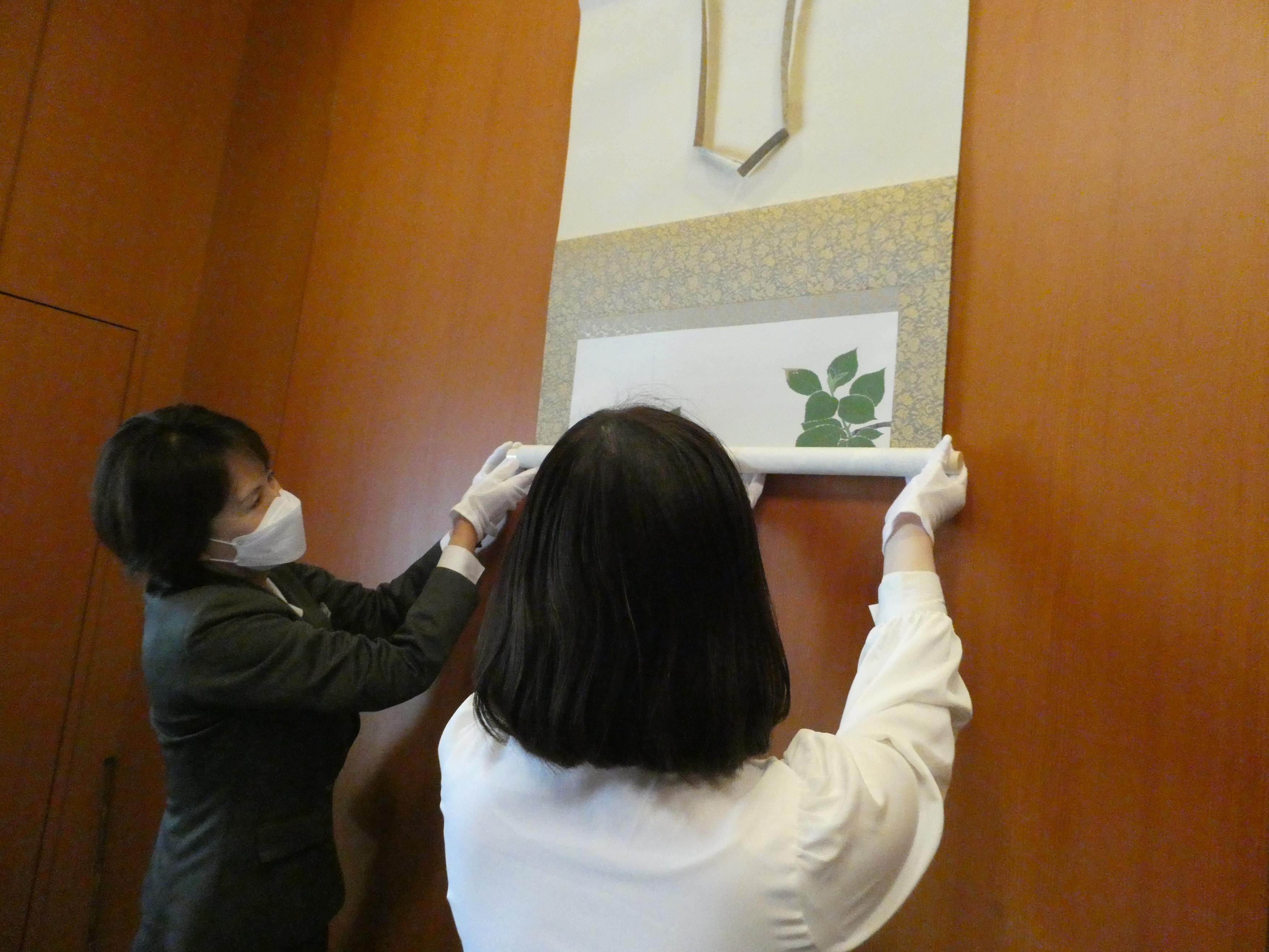 掛軸を巻き上げる